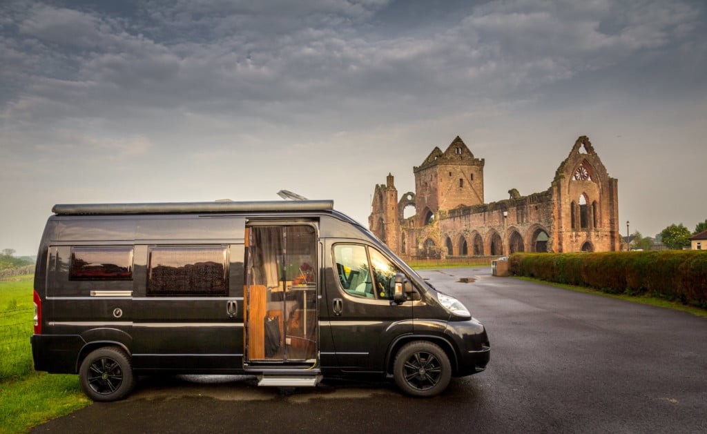 Schwarzes Wohnmobil beim Wildcampen vor der Sweetheart Abbey in Dumfries, Schottland