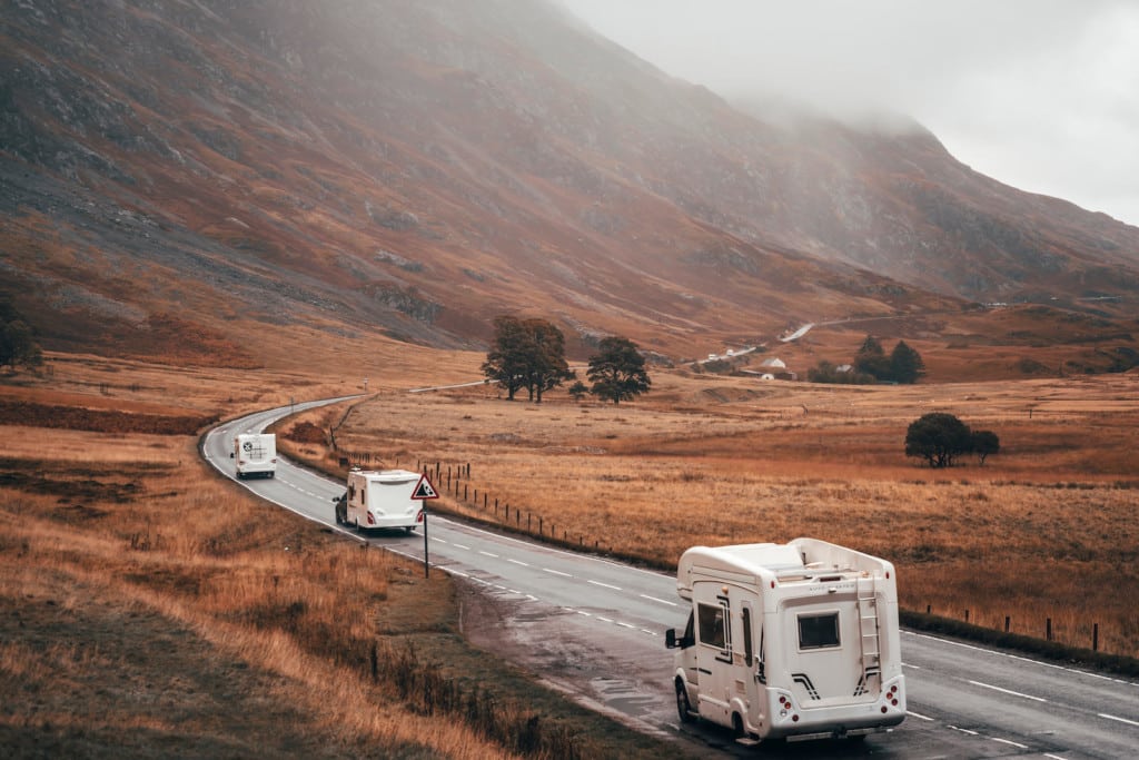 Schottland mit dem Wohmobil: Wohnmobile auf einer kurvigen Straße in Glencoe, Schottland